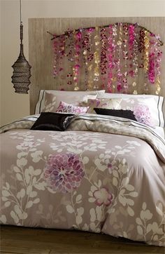 a bed with pink and brown flowers on it