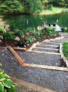 a path made out of wooden planks leading to a lake