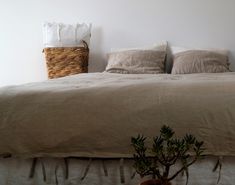 a bed with two pillows and a basket on the headboard in front of it