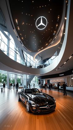 a mercedes car is on display in a showroom with people walking around the building