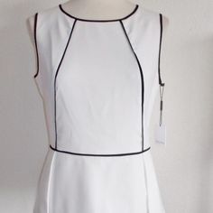 Calvin Klein Misses Size Medium Fashion Blouse / Top Off White In Color With Black Piping Sleeveless Peplum Waist Back Zipper With Hook & Eye Closure 97% Polyester 3% Spandex Chic White Peplum Blouse, Chic White Peplum Top, White Sleeveless Office Top, White Elegant Peplum Top, Elegant Sleeveless Spring Peplum Top, Elegant White Tank Blouse, Chic White Tank Top For Work, Fitted Sleeveless Peplum Top For Workwear, Elegant White Peplum Top For Summer