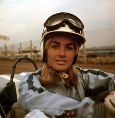 a woman in a helmet and goggles sitting in a car