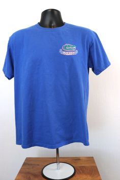 Florida Gators Graphic Tee  Vintage Florida Gators Graphic Tee.  Graphics on both the front and back.  Back graphic covers majority of the shirt with a full-size mascot.  Shown on both male and female mannequin. M&O Knits Heavy Weight Tag 100% Cotton (Preshrunk) Size: Adult Medium Crew Neck Tops With Front Print For Fan Gear, Front Print Crew Neck Tops For Sports Events, Crew Neck Tops With Front Print For Sports Events, Florida Gator Outfits, Florida Gator Shirts Woman, Florida Gators Shirt, Florida Gators Logo, Florida Gators Baseball, Female Mannequin