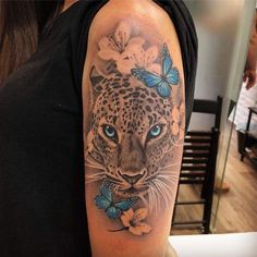 a woman's arm with a leopard and butterflies on it