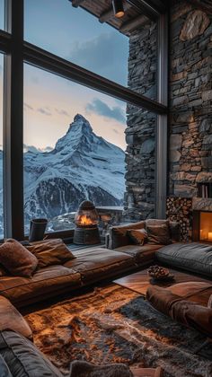 a living room filled with furniture and a fire place in front of a large window