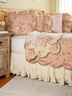 a bed with pink flowers and ruffled bedspread