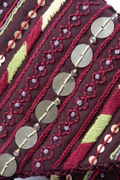 a close up of a decorative pillow with buttons on it's sides and thread