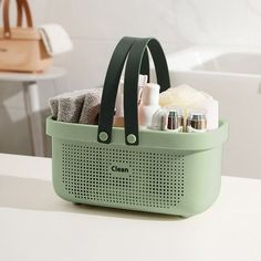 a green basket filled with personal care items on top of a counter next to a bath tub