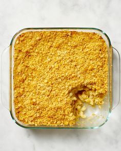 a casserole dish filled with macaroni and cheese on a marble surface