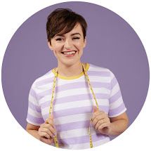 a woman wearing a purple and white striped shirt holding a yellow lanyard around her neck