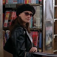 a woman standing in front of a book shelf