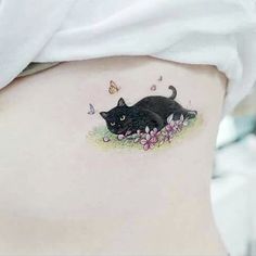 a woman's stomach with a black cat tattoo on it