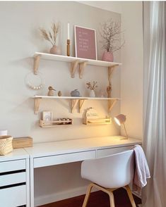 a white desk with some shelves above it and a chair in front of the desk