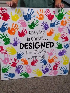 a child holding a sign that says created in christ designed for god's purpose