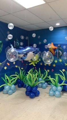 an under the sea scene with bubbles, fish and other marine creatures on display in front of a blue wall