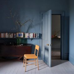 a chair sitting in front of a book shelf with books on it's shelves