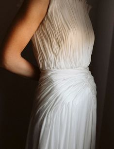 a woman in a white dress is posing for the camera