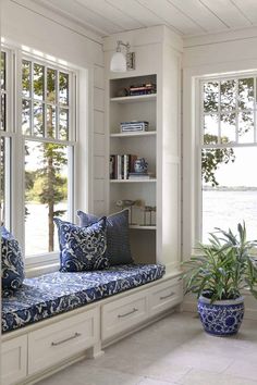 a blue and white window seat with pillows on it