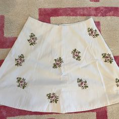 White Mini Skirt With Embroidered Flower Details. Never Worn. White Fitted Skirt With Floral Embroidery, White Skirt With Floral Embroidery, Fitted White Skirt With Floral Embroidery, White Embroidered Mini Skirt, Spring Cotton Skirt With Floral Embroidery, Spring Embroidered Cotton Skirt, Cotton Mini Skirt With Floral Embroidery, Fitted White Skirt With Embroidered Hem, White Mini Skirt