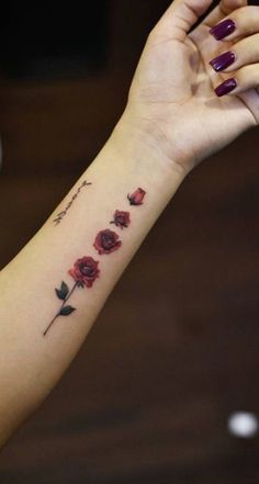 a woman's arm with roses on it and the word love written in cursive writing