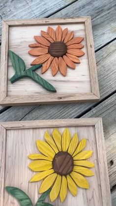 two wooden framed pictures with sunflowers painted on the sides and green leaves in the middle