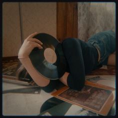 a person laying on the floor with a record in their hand