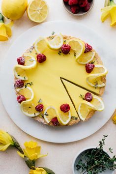 a cake with lemons and raspberries on it