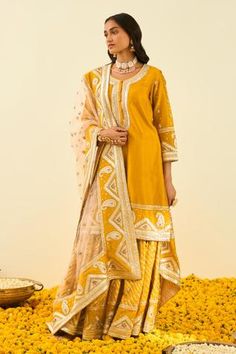 Glaze mustard short kurta with gota patti embroidery highlighted with basra moti. Paired with embroidered gharara and silk organza rose pink dupatta.
Component: 3
Pattern: Embroidered
Type Of Work: Floral, Paisley
Neckline: Round
Sleeve Type: Long Sleeves
Fabric: Kurta and Gharara - Silk Chanderi; Dupatta - Silk Organza
Color: Yellow
Other Details: 
Gota and bead work
Embroidered dupatta
Occasion: Wedding,Sangeet - Aza Fashions Yellow Kurta, Pink Dupatta, Chanderi Dupatta, Short Kurta, Embroidered Dupatta, Indian Fashion Designers, Pernia Pop Up Shop, Silk Organza, Set For Women