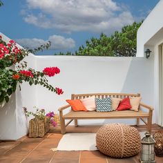 a wooden bench sitting on top of a tiled floor next to a flower filled wall