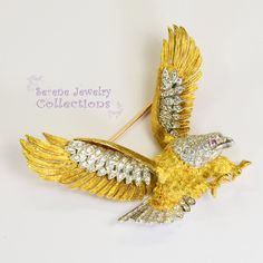 Absolutely beautiful McTiegue 18k gold Vintage Eagle Brooch designed in both platinum and 18k yellow gold! Exactly 100 white sparkly diamonds adorn the eagle's wings, tail and head, and has a ruby eye! Powerful piece! Total Weight: 26.5 grams Size: 2.3 inch x 2 inch Precious Metal: 18k yellow gold, Platinum Precious stones: -Ruby Eagle eye: 1.3mm, QTY: 1 -White Round Diamonds: QTY: 100, 2 carats Hallmark: Plat, 18k Exquisite Diamond Brooches In Yellow Gold, Exquisite Yellow Gold Diamond Brooches, Yellow Gold Diamond Brooch Fine Jewelry, Diamond Yellow Gold Brooches Fine Jewelry, Yellow Gold Diamond Brooches Fine Jewelry, Yellow Gold Diamond Brooch In Fine Jewelry Style, Yellow Gold Diamond Brooches For Formal Occasions, Formal Yellow Gold Diamond Brooch, Gold Diamond Brooches As Gift