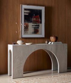 a white console table with two vases and a painting on the wall behind it