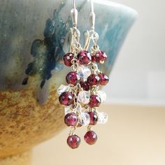 Flirty and sophisticated garnet dangle earrings are handmade with small natural garnet gemstones finely faceted for added sparkle and clear Swarovski crystals cascading down a sterling silver chain. Give a January born girl a unique and artisan gift which she can dress up in. Garnet is the birthstone for January born women. Earrings Details: - Garnet earring length is 1.75 inches  (4.45 cm) with the earrings closures - Sterling silver wire, chain and leverback findings. Available in gold filled. - Garnet earrings will arrive carefully packaged in a jewelry box with a ribbon Fine Heart jewelry are always handmade and custom fitted.  - Customize the earring findings; please use the drop down menu - Choose your metal preference; available sterling silver (shown) and gold filled LOVE garnets? Garnet Faceted Drop Earrings, Faceted Garnet Drop Earrings, Garnet Faceted Earrings For Gift, Garnet Birthstone Drop Earrings, Handmade Garnet Earrings For Anniversary, January Born, Red Garnet Jewelry, Red Garnet Earrings, Birthday Stone