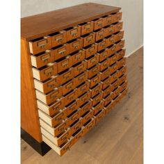 a large wooden cabinet with many drawers on it's sides and one drawer open