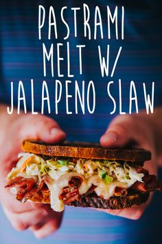 a person holding a sandwich in their hands with the words pastami melt w / jalapeno slaw