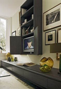 a living room filled with furniture and pictures on the wall next to a flat screen tv