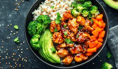 a bowl filled with chicken, broccoli and rice next to an avocado