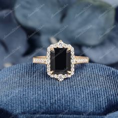 an engagement ring with a black stone surrounded by diamonds