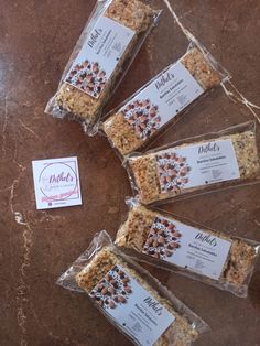 five bags of granola sitting on top of a table next to a label that says dolce's