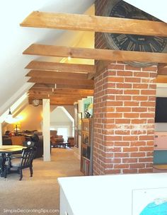 an open living room and dining area with a clock on the wall