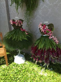 two vases filled with flowers sitting next to each other on top of green grass