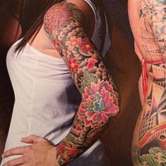 two people with tattoos standing next to each other