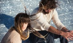 a man and woman sitting next to each other on a skateboard in the water