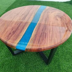 a wooden table sitting on top of grass next to a blue stripe in the center