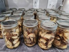 several jars filled with sliced apples sitting on a table