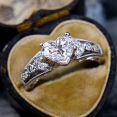 a heart shaped diamond ring in a velvet box