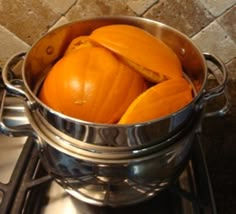 a pot full of pumpkins sitting on top of a stove