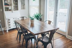 a dining room table with chairs and a potted plant