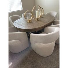 a dining room table with white chairs around it