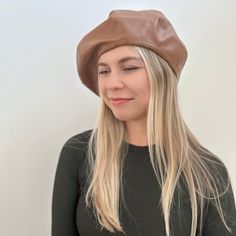 a woman with long blonde hair wearing a brown hat