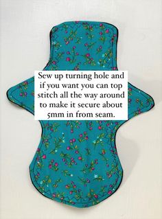 a blue bib with pink flowers on it that says sew up turning hole and if you want you can top stitch all the way around to make it secure about 5mm in from seam